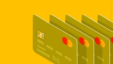 Зеленые банковские карты с чипом и логотипом Mastercard на желтом фоне.