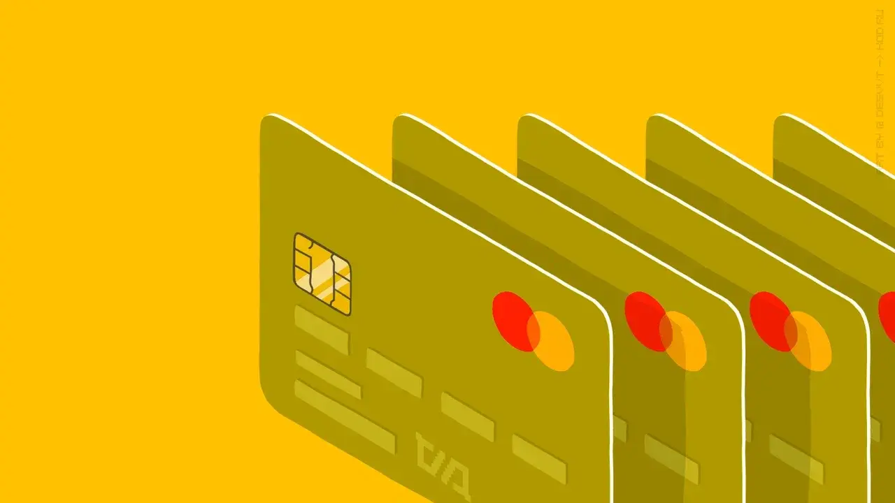 Зеленые банковские карты с чипом и логотипом Mastercard на желтом фоне.