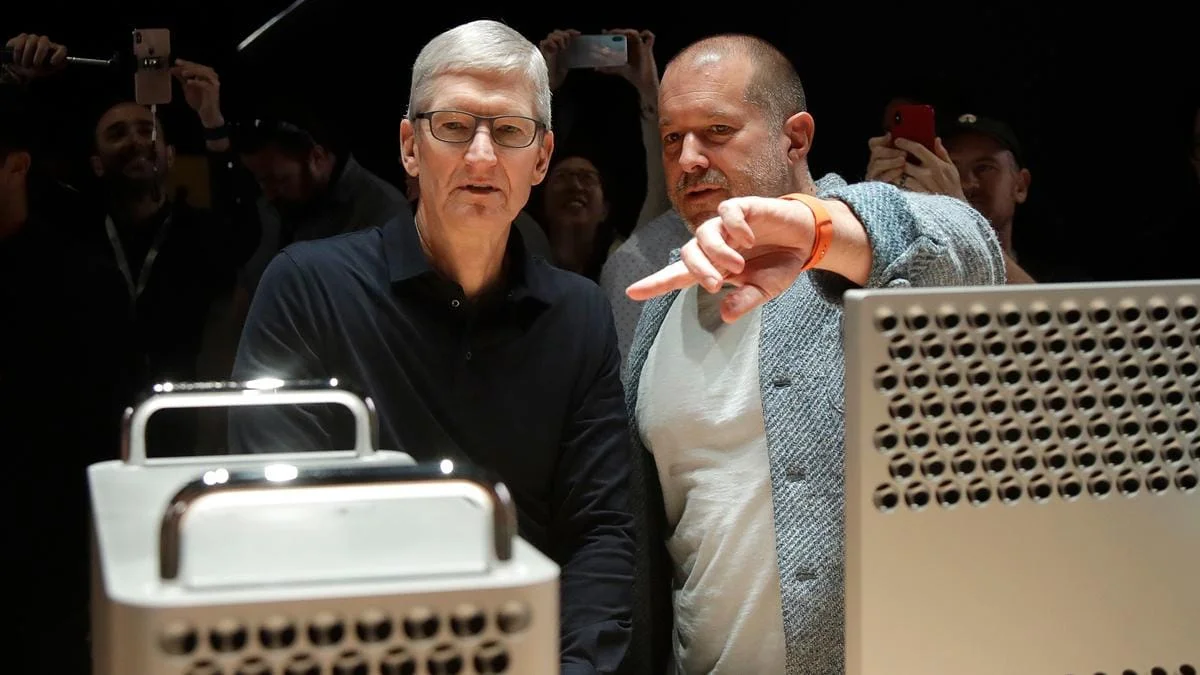 Тим Кук и Джони Айв стоят рядом с компьютерами Mac Pro, Айв указывает рукой.