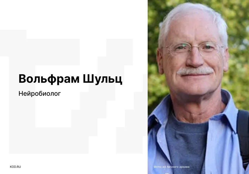 На фото улыбающийся мужчина средних лет с седыми волосами, усами, в очках и голубой рубашке, смотрит прямо в камеру.