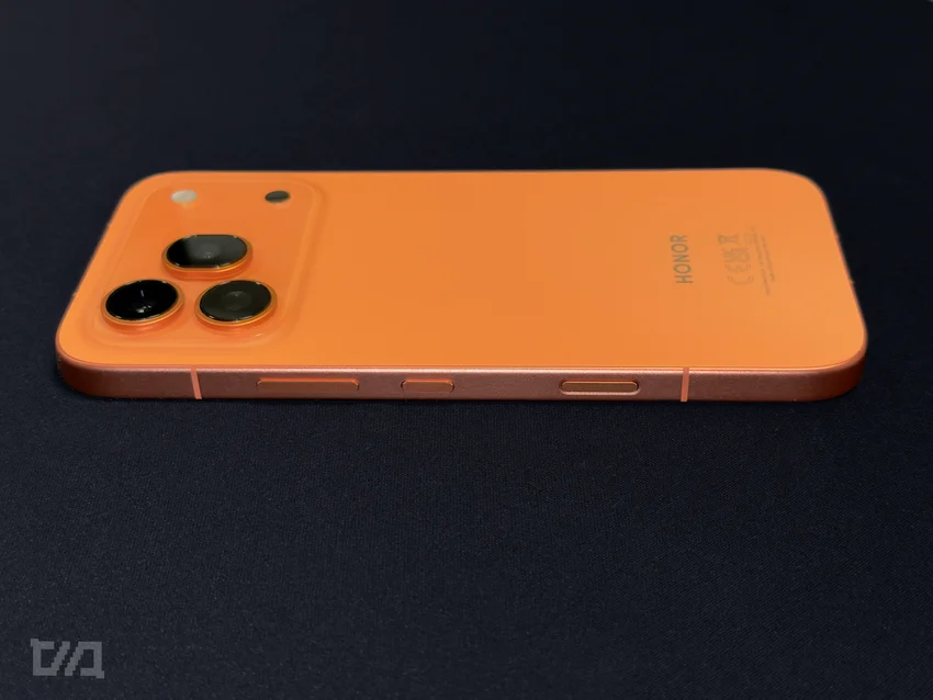 Оранжевый смартфон Honor 600 Pro на тёмном фоне. Видна задняя панель, блок камер, логотип.