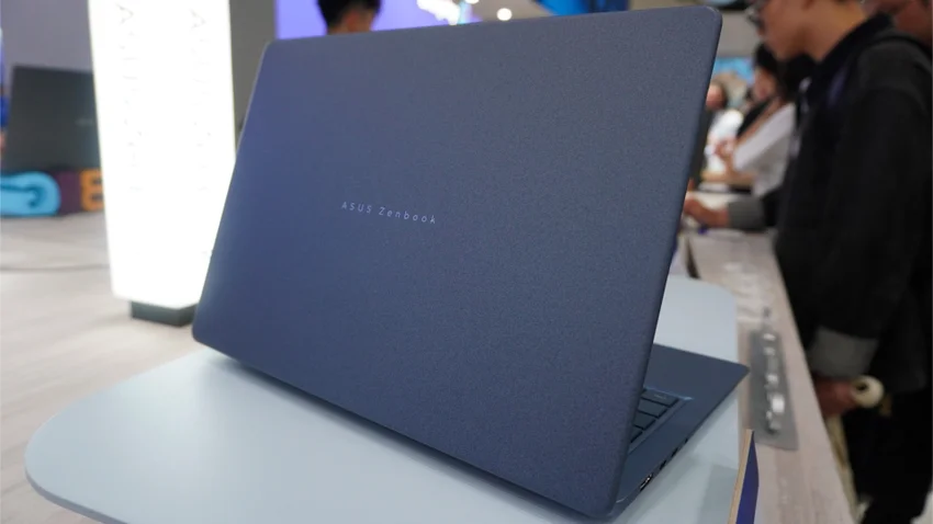 Синий ноутбук ASUS Zenbook открыт на выставочном стенде.