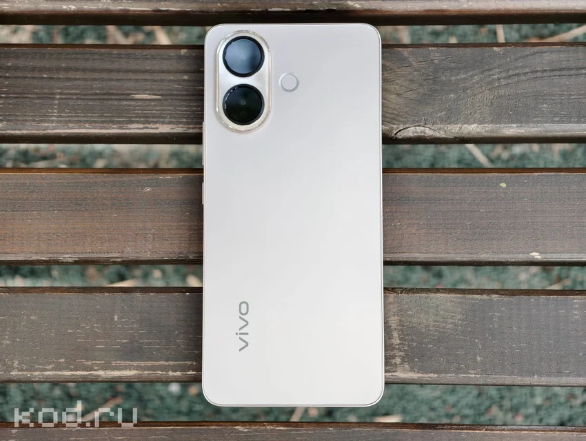 Смартфон vivo V70 Lite 5G белого цвета с двумя камерами на деревянной скамье.
