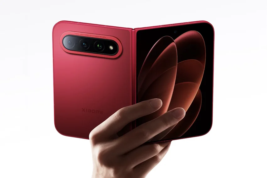 Красный складной смартфон Xiaomi в руке, открыт, видна камера и экран с абстрактным узором.